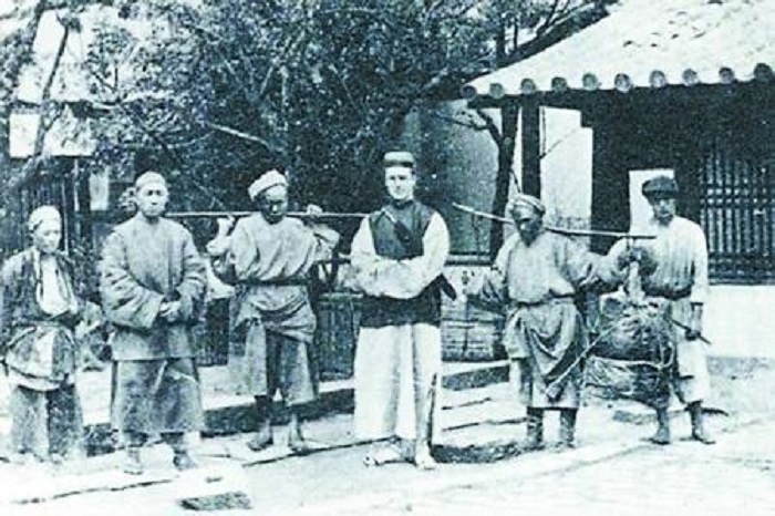 1894年，澳大利亚人乔治·莫理循与几名重庆挑夫的合影。